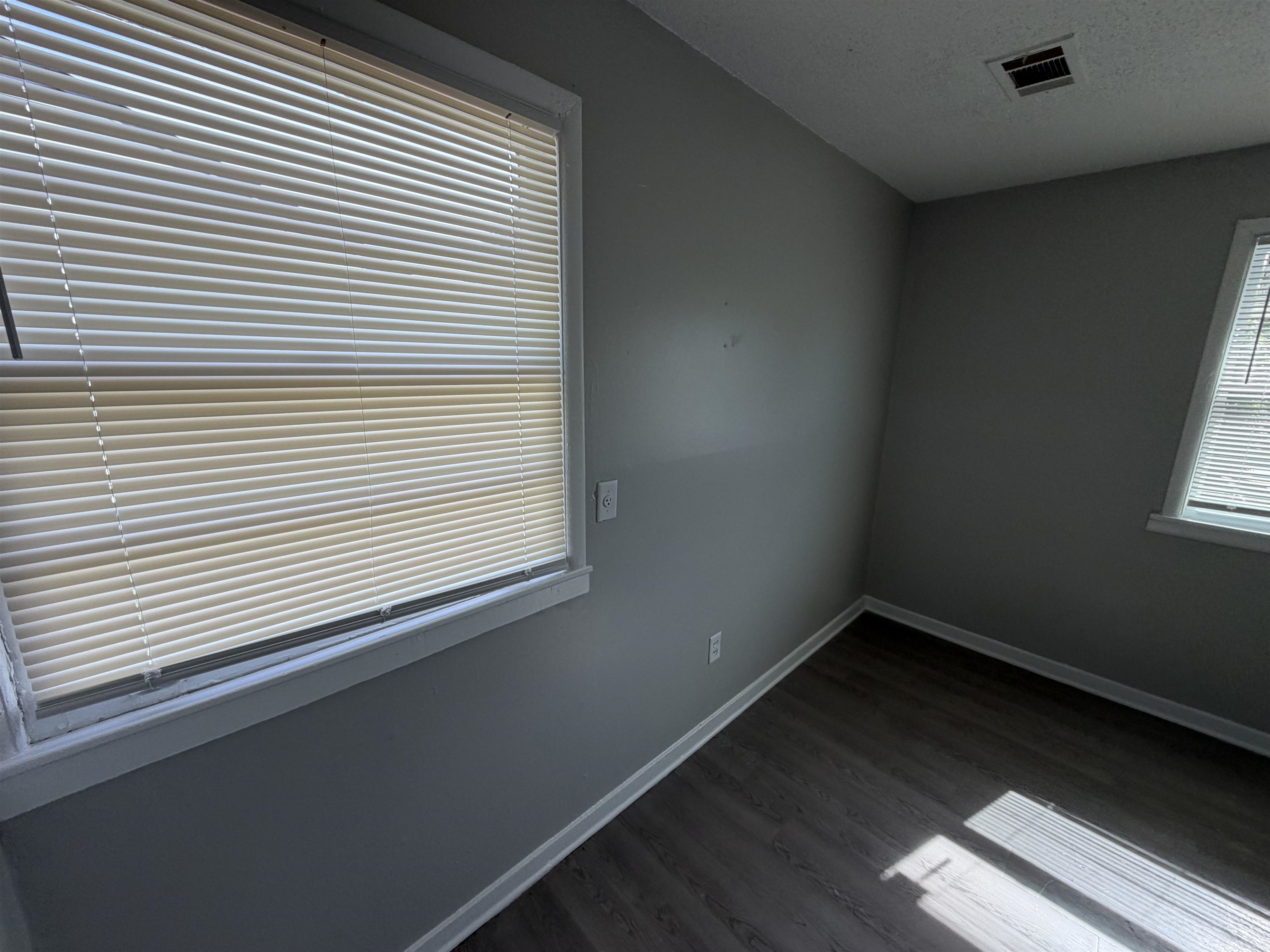 3525 Rochester Road Memphis, TN 38109 - Photo 9 of 10 Room featuring dark wood-finish flooring, light gray wall paint, and white trim