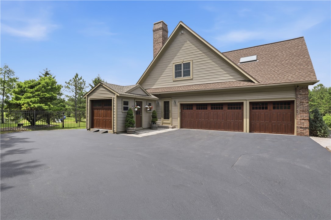 2057 Stirnie Road Victor, NY 14564 - Photo 37 of 48 The front exterior boasts an expansive paved driveway providing a wealth of parking space, leading to a 3 car attached garage. Complete with beautiful carriage-style wood garage doors, brick accents, and a charming covered secondary entrance.