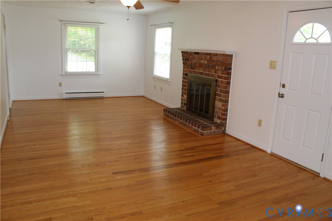 16524 Benmore Road Moseley, VA 23120 - Photo 13 of 43 an empty room with wooden floor fireplace and windows
