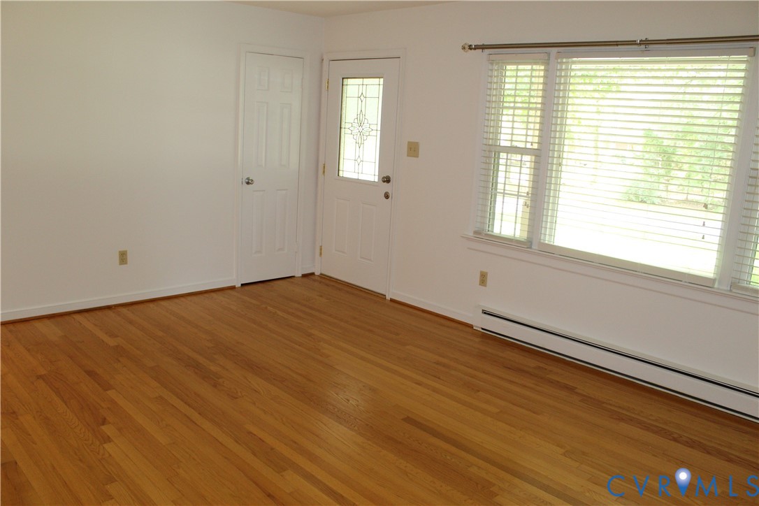 16524 Benmore Road Moseley, VA 23120 - Photo 23 of 43 a view of an empty room with wooden floor and a window