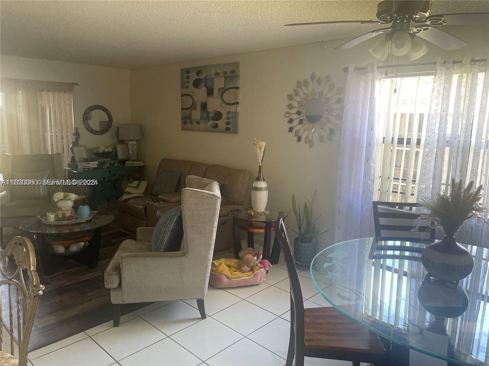3399 Foxcroft Road, Unit 315 Miramar, FL 33025 - Photo 5 of 9 a living room with furniture and a chandelier