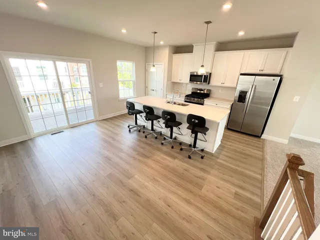 a view of kitchen with refrigerator microwave and wooden floor