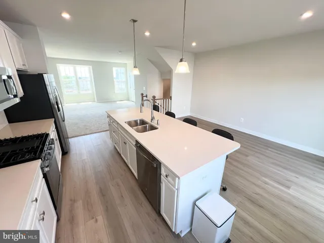 a large white kitchen with wooden floor