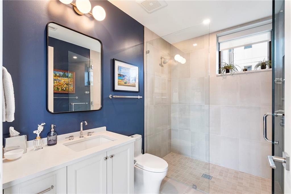 2520 Peachtree Road West, Unit 1203 Atlanta, GA 30305 - Photo 40 of 65 a bathroom with a toilet a sink a mirror a vanity and shower