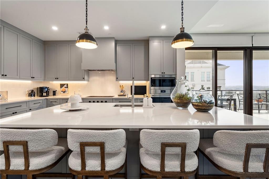 2520 Peachtree Road West, Unit 1203 Atlanta, GA 30305 - Photo 8 of 65 a kitchen with granite countertop a table chairs stove and microwave
