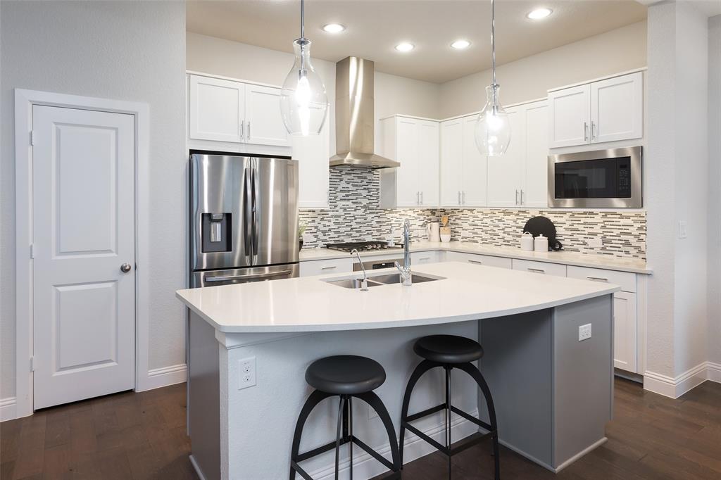 1115 Manacor Lane Dallas, TX 75212 - Photo 14 of 28 a kitchen with stainless steel appliances kitchen island granite countertop a kitchen island and chairs in it