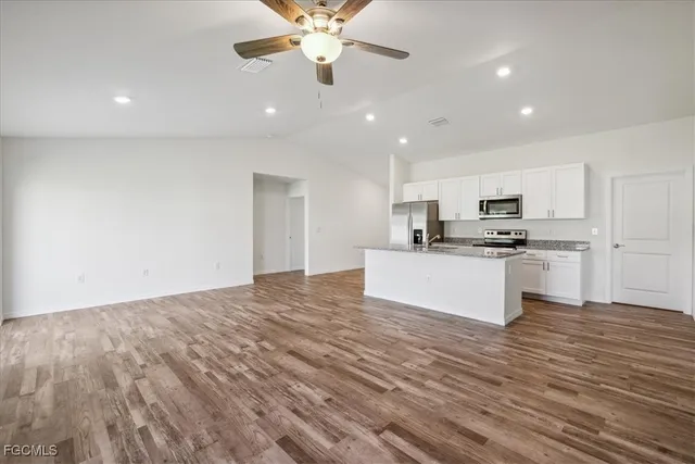 a view of kitchen with granite countertop cabinets and refrigerator