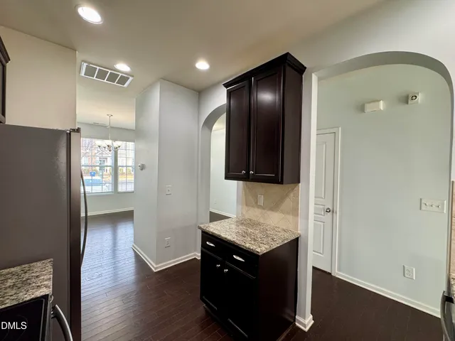 an empty room with windows and fireplace