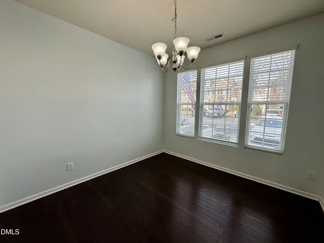 a view of a room with wooden floor and a chandelier