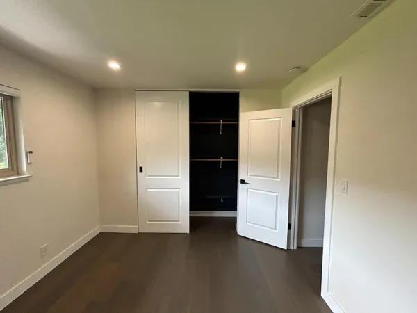 an empty room with closet and wooden door