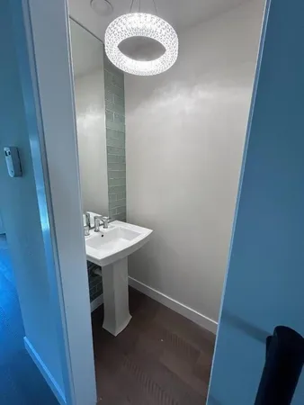 a bathroom with a sink a light fixture and a mirror