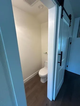 a bathroom with a granite countertop toilet and a sink