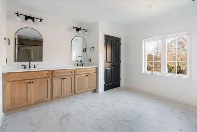 a spacious bathroom with double sink and a mirror