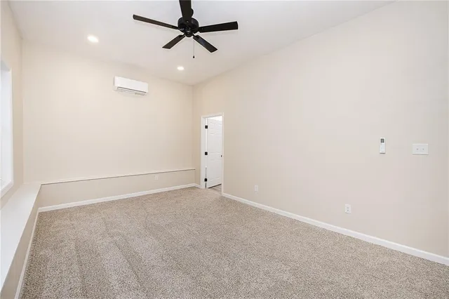 an empty room with a ceiling fan and carpet