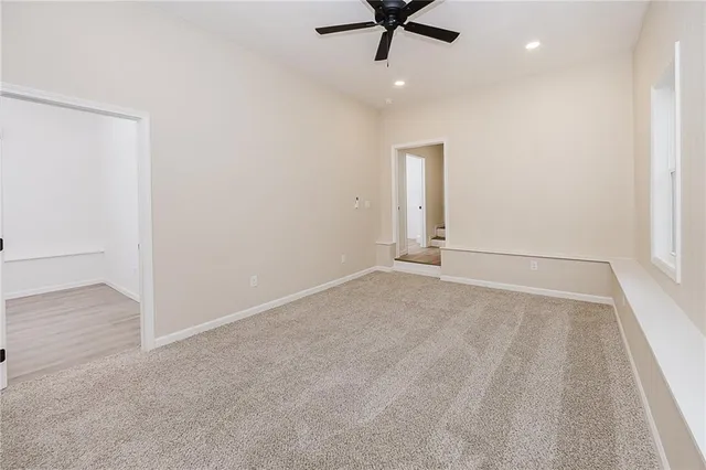 an empty room with a ceiling fan and hardwood floor