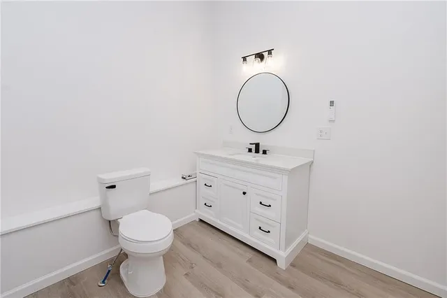 a bathroom with a toilet sink vanity and mirror
