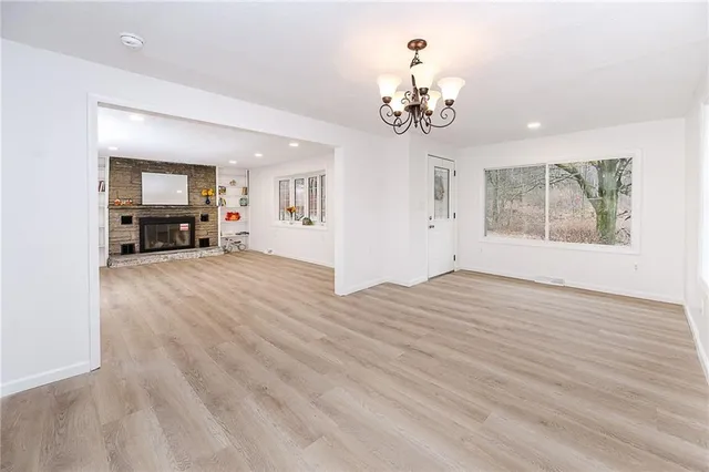 a view of a livingroom with furniture cabinet wooden floor and a chandelier
