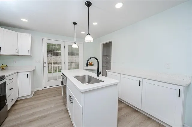 a kitchen that has a sink a stove and dishwasher with wooden floor