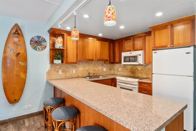 a kitchen with stainless steel appliances granite countertop a stove a sink and a refrigerator