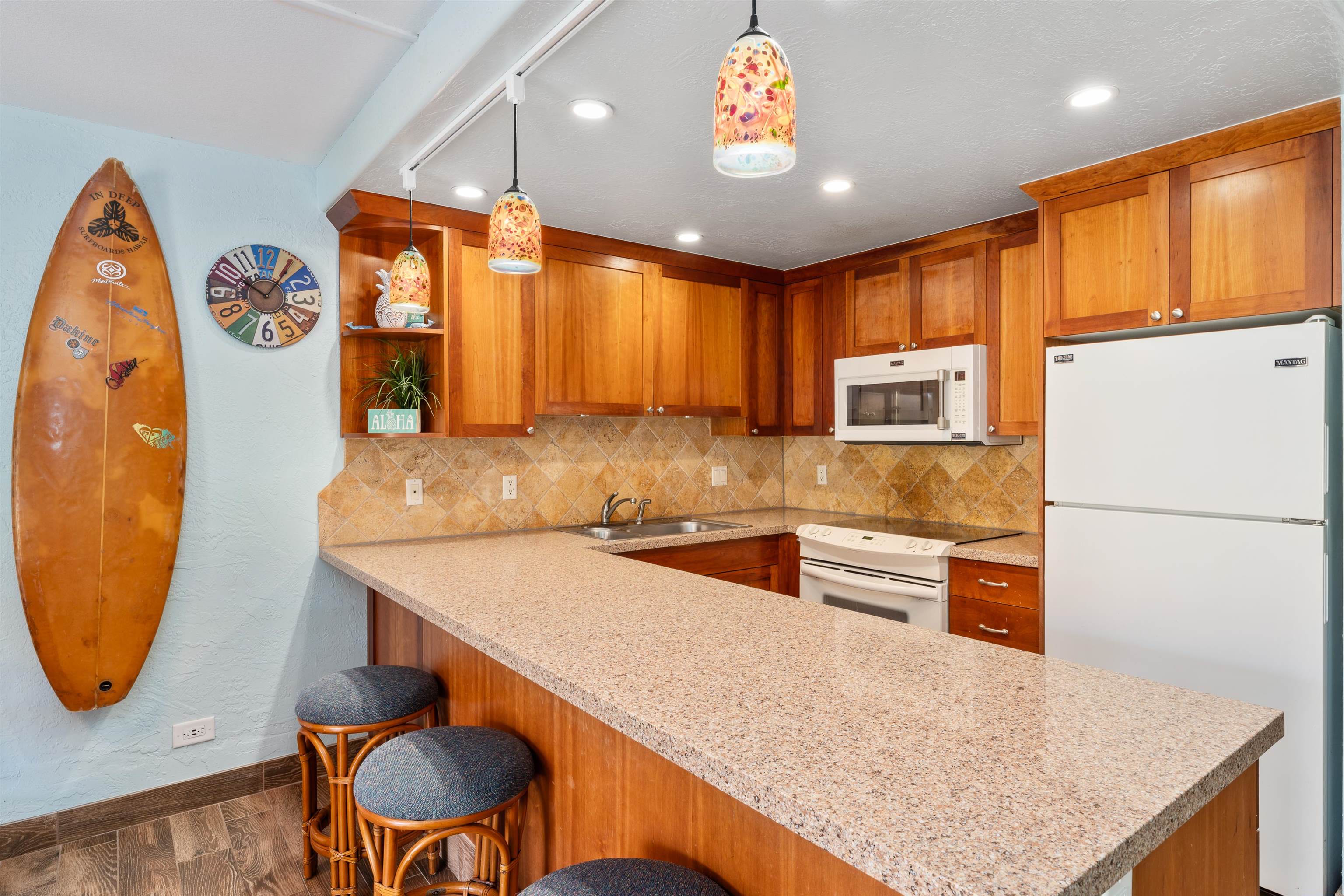 3543 Lower Honoapiilani Road, Unit G103 Lahaina, HI 96761 - Photo 16 of 47 a kitchen with stainless steel appliances granite countertop a sink a stove a refrigerator cabinets and chairs