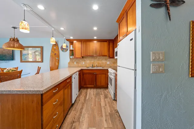 a kitchen with stainless steel appliances granite countertop sink stove refrigerator and cabinets