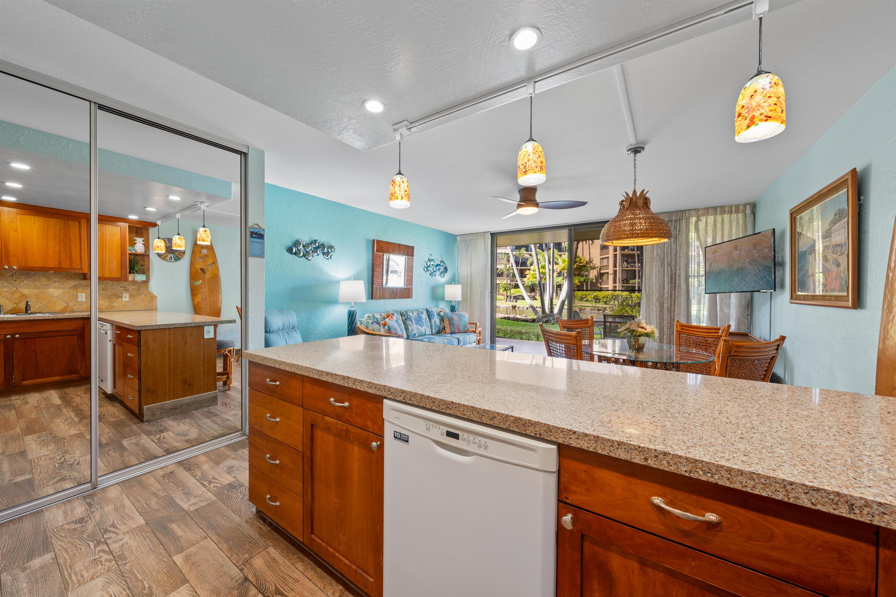 3543 Lower Honoapiilani Road, Unit G103 Lahaina, HI 96761 - Photo 19 of 47 a kitchen with stainless steel appliances granite countertop a sink a stove and a wooden cabinets