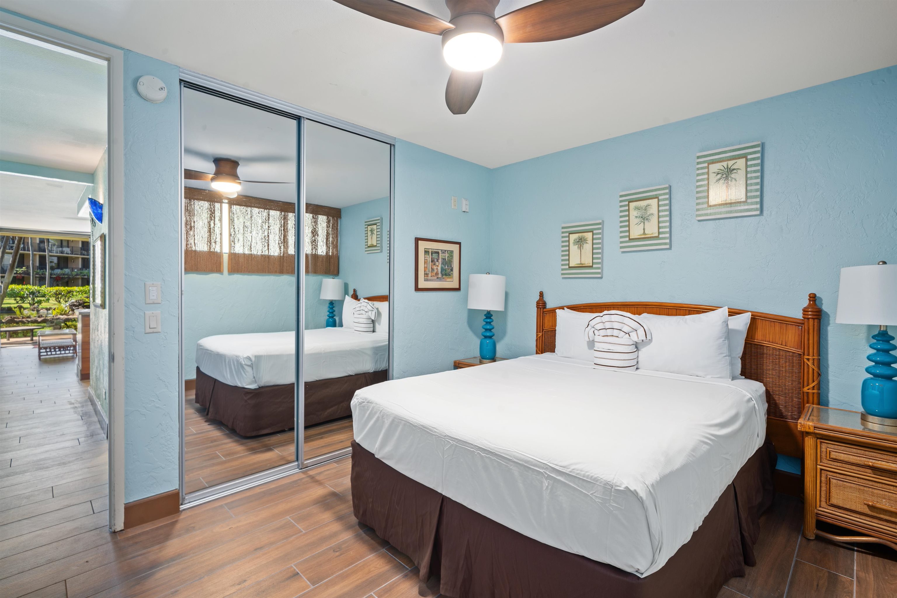 3543 Lower Honoapiilani Road, Unit G103 Lahaina, HI 96761 - Photo 23 of 47 a bedroom with a bed a mirror and lamp