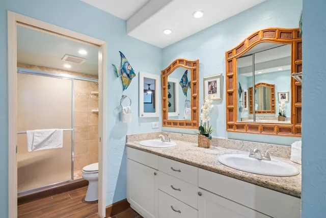 a spacious bathroom with double vanity and a mirror