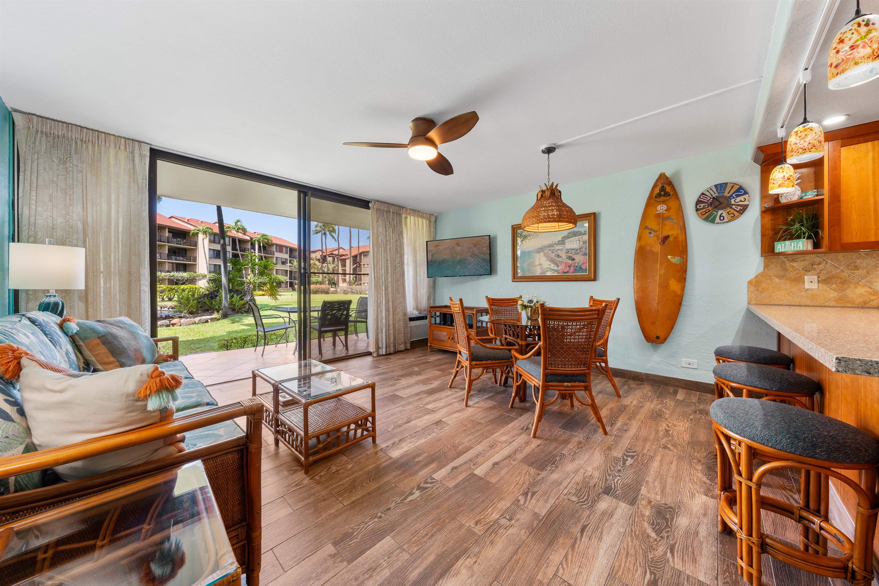 3543 Lower Honoapiilani Road, Unit G103 Lahaina, HI 96761 - Photo 35 of 47 a living room filled with furniture a rug potted plant kitchen view and a large window