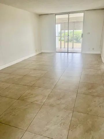 a view of a room with a ceiling fan and window