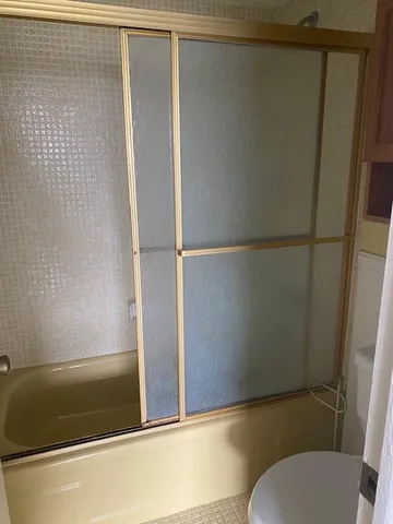 a bathroom with a granite countertop sink and a toilet