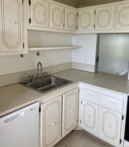 a kitchen with white cabinets and sink