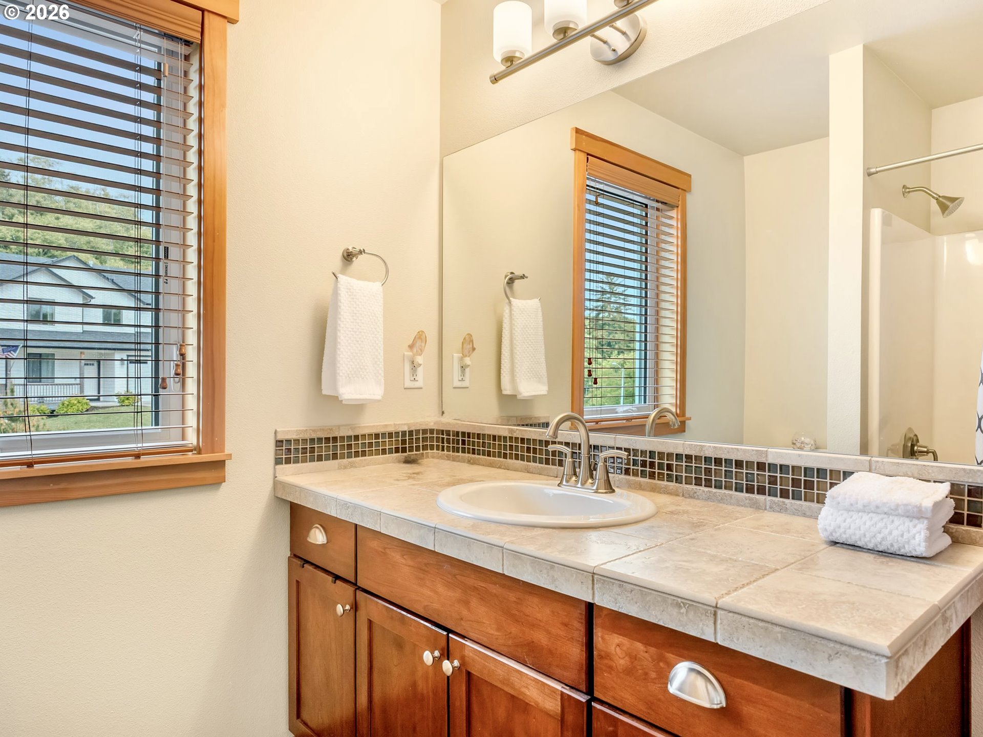 2372 North Fork Road Seaside, OR 97138 - Photo 39 of 48 a bathroom with a granite countertop sink and a large mirror