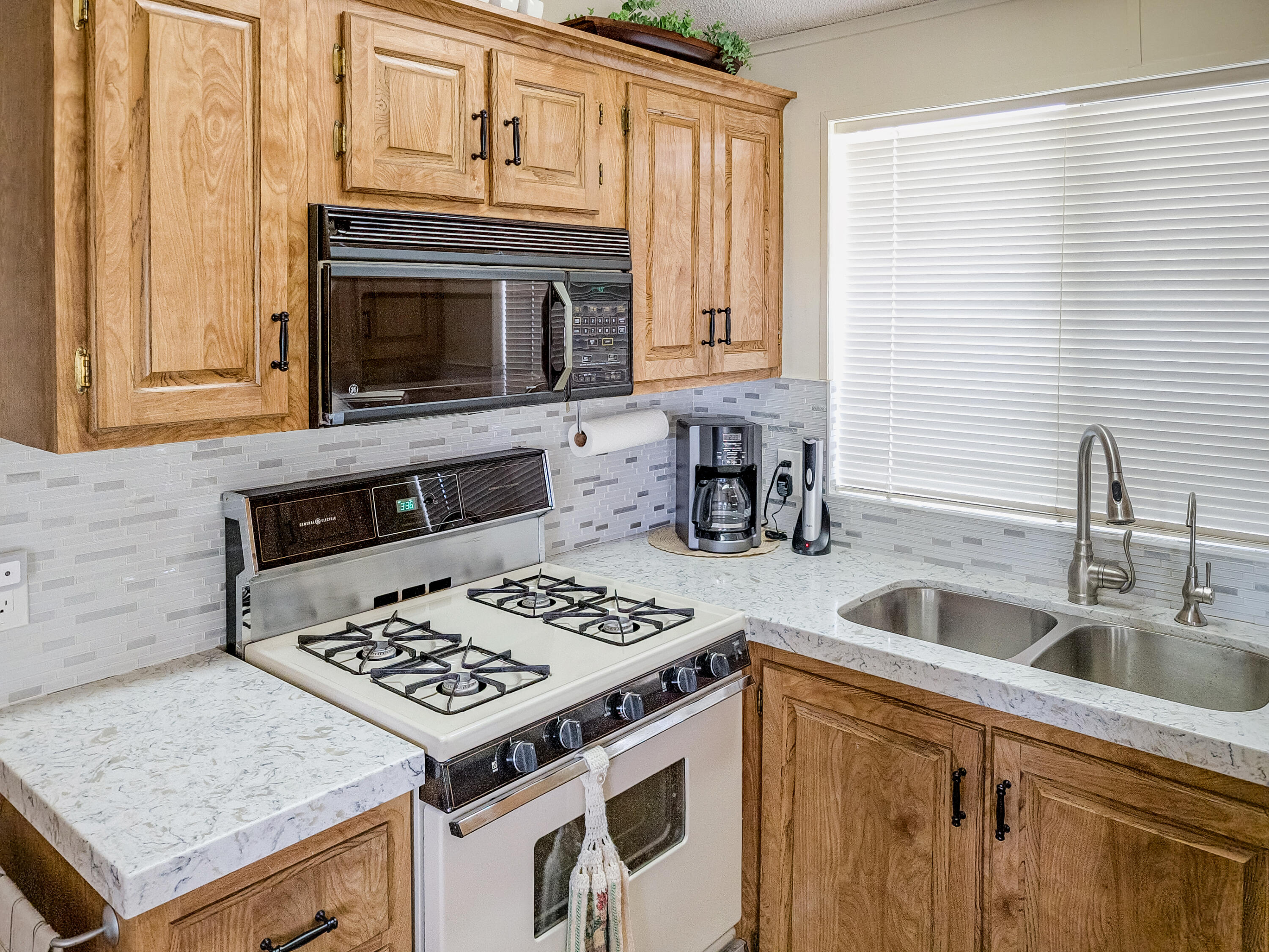70200 Dillon Road, Unit 160 Desert Hot Springs, CA 92241 - Photo 8 of 31 a kitchen with granite countertop a sink stove and cabinets