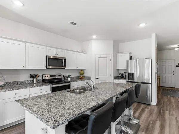a kitchen with granite countertop a sink counter top space appliances and cabinets