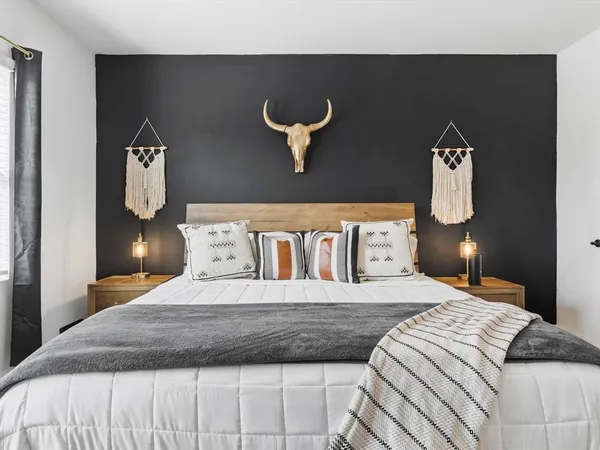 a bedroom with a bed and painting on the wall