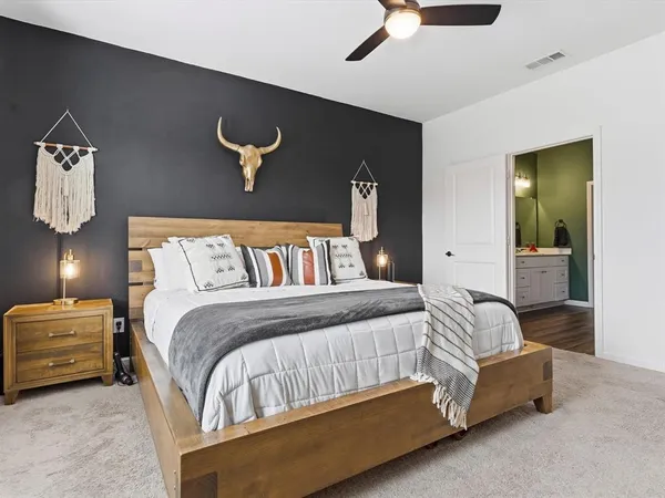 a bedroom with a bed and painting on the wall