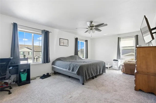 a spacious bedroom with a bed a dresser and a window