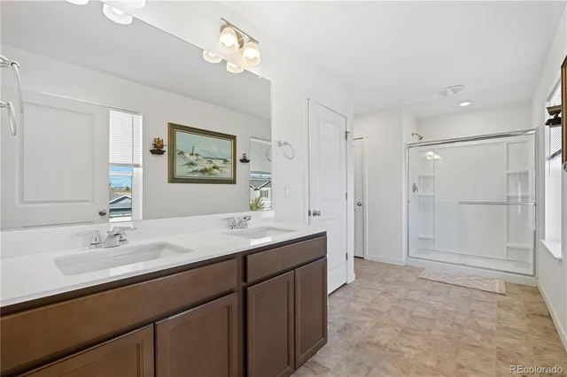 a spacious bathroom with a shower sink and mirror