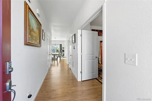 a view of a hallway with wooden floor and dining room