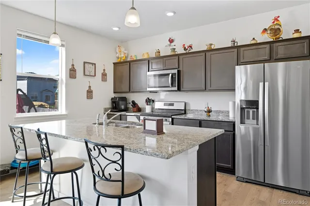 a kitchen with stainless steel appliances granite countertop a kitchen island a stove a table and chairs