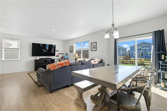 a living room with furniture a flat screen tv and floor to ceiling window