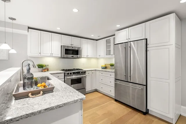 a kitchen with granite countertop a refrigerator stove top oven and sink