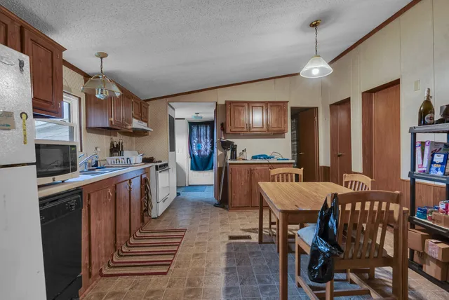a large kitchen with cabinets table and chairs