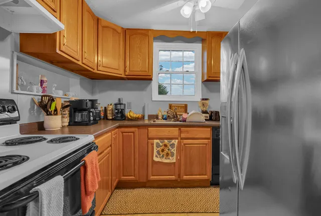 a kitchen with stainless steel appliances granite countertop a refrigerator and a stove top oven
