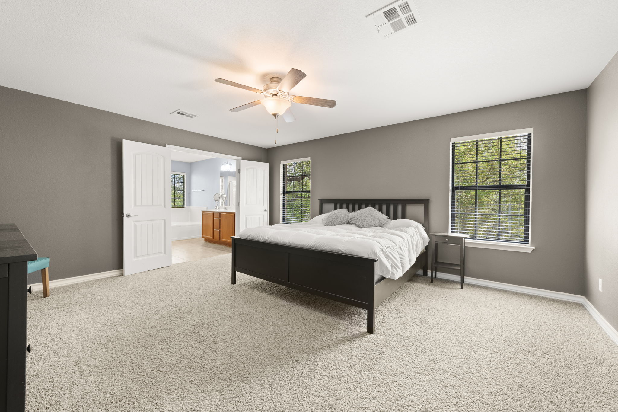 7629 Brecourt Manor Way Austin, TX 78739 - Photo 17 of 40 a spacious bedroom with a bed and a chandelier