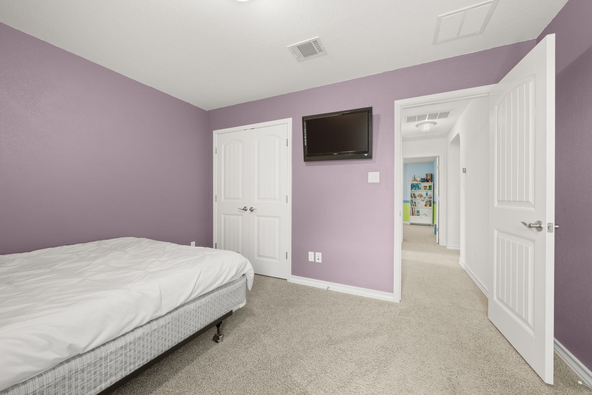 7629 Brecourt Manor Way Austin, TX 78739 - Photo 23 of 40 a bedroom with a bed and a flat screen tv