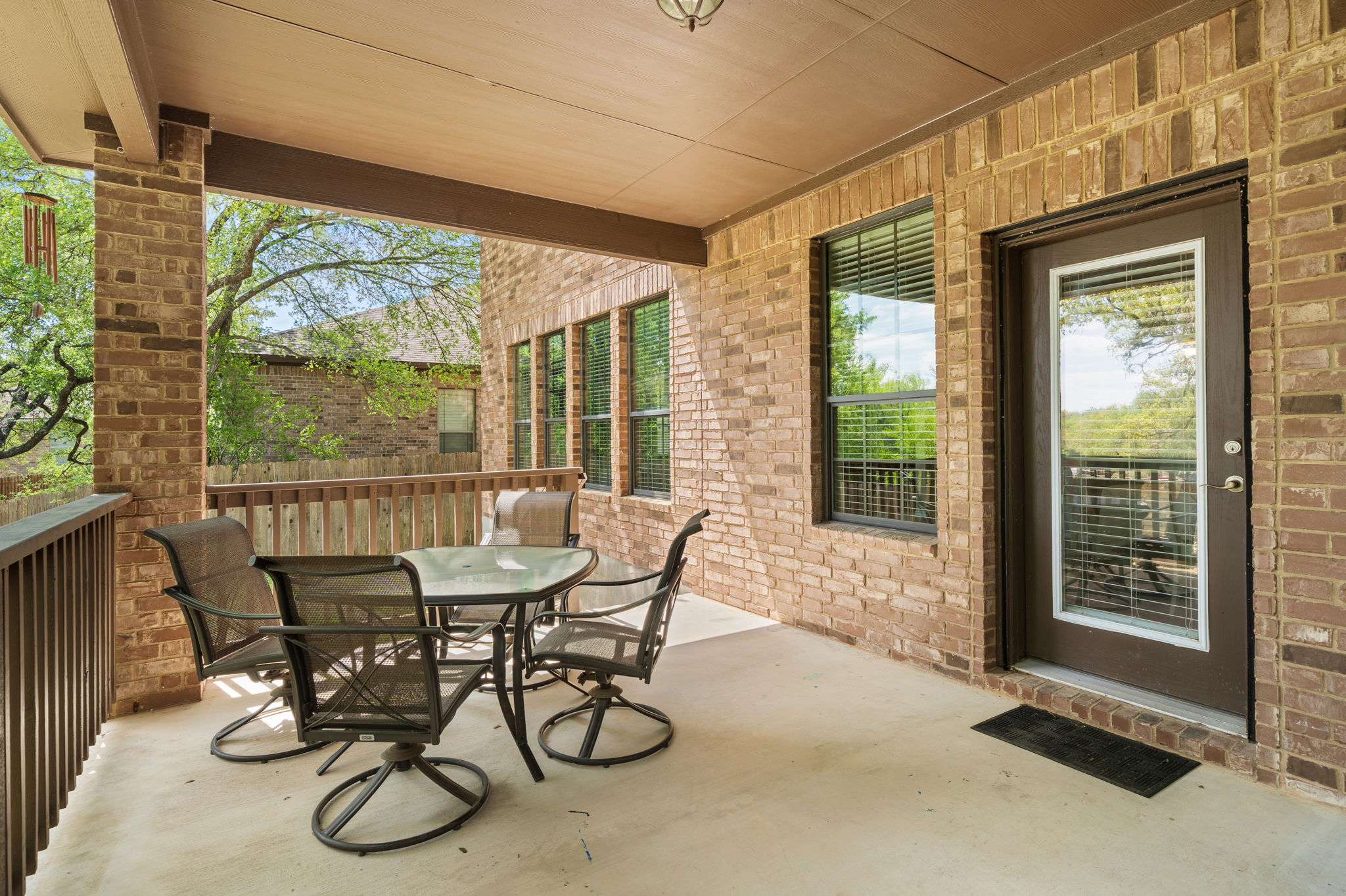 7629 Brecourt Manor Way Austin, TX 78739 - Photo 34 of 40 a view of a patio with table and chairs and floor to ceiling window