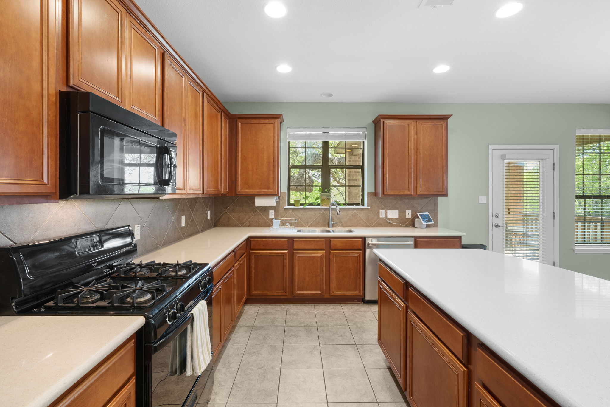 7629 Brecourt Manor Way Austin, TX 78739 - Photo 6 of 40 a kitchen with a sink stove top oven and cabinets