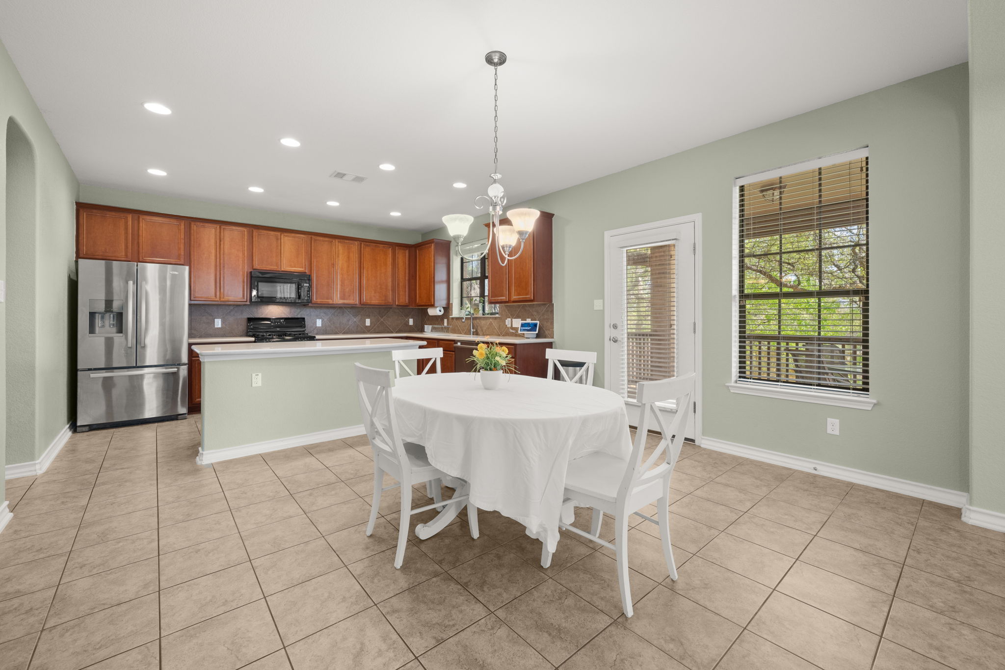 7629 Brecourt Manor Way Austin, TX 78739 - Photo 8 of 40 a kitchen with stainless steel appliances granite countertop a stove a sink a refrigerator and a microwave